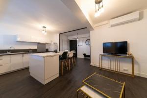eine Küche und ein Wohnzimmer mit Theke und Fernseher in der Unterkunft Superbe appartement centre historique in Avignon