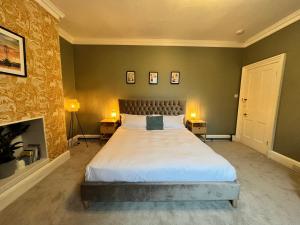 a bedroom with a large bed and a fireplace at Mossley Hill Retreat in Liverpool