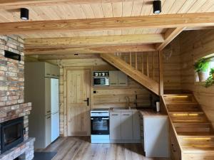 a kitchen with a staircase in a log house at Pod Skałką in Nienadowa