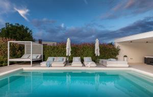 a pool with chairs and umbrellas next to at 3 Bedroom Amazing Home In Pula in Pula