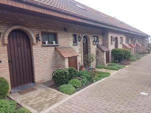 a brick house with two doors and a window at Golfbreker in De Haan
