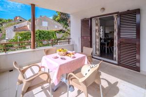 a table and chairs on the balcony of a house at Moenia Apartments in Milna