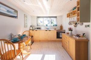 a kitchen with a table and chairs in a room at The Langland Loft - Tiny Home in The Mumbles