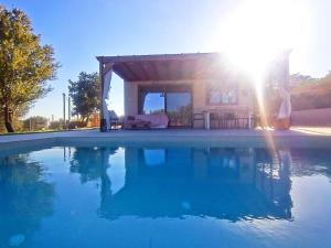 Eine Person steht neben einem Haus mit Swimmingpool. in der Unterkunft Imagio 22 in Sálakos