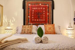 a bedroom with a bed with towels and a rug at Typique maison in Dar Mimoun Bey