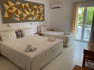 a bedroom with two beds and a balcony at Manolis' House in Skiathos Town +75 photos