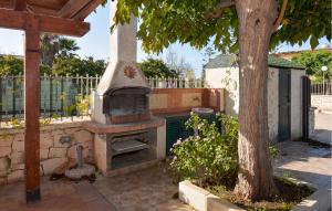 einen Außenofen in einem Hof neben einem Baum in der Unterkunft 3 Bedroom Nice Home In Marina Di Modica in Marina di Modica
