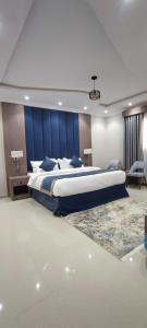 a bedroom with a large bed with a blue headboard at اجنحة مأرز الايمان in Medina