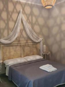a bedroom with a canopy bed with towels on it at Dimora Storica Silver Room in Ruviano