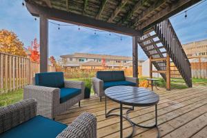 a patio with chairs and a table and a staircase at Cozy Cottage for Fall Getaways, Private backyard, decks in Meaford