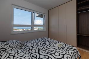 une chambre avec un lit et une grande fenêtre dans l'établissement Luxury Apartment NARONA Sea&City view, à Makarska