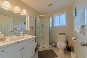 a bathroom with a shower and a toilet and a sink at Cozy Cottage for Fall Getaways, Private backyard, decks in Meaford +34 photos