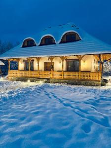 un edificio coperto di neve nella neve di Casa Moroșanului Vișeu de Sus a Vişeu de Sus