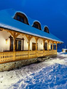 un edificio con la neve sul terreno di fronte di Casa Moroșanului Vișeu de Sus a Vişeu de Sus Altre 68 foto