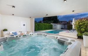 a large pool with a hot tub in a house at 3 Bedroom Amazing Home In Pula in Pula