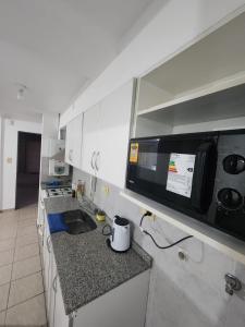 une cuisine avec un évier et un micro-ondes dans l'établissement Depto av cordoba 2, à Barrio Rivadavia
