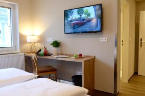 Pokój z biurkiem i telewizorem na ścianie w obiekcie Hotel FIVE w Norymberdze
