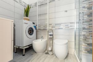 a bathroom with a washing machine and a toilet at Vista mare AirPort in Fiumicino +22 photos