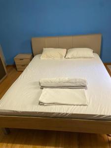 a bed with white sheets and pillows on it at Solonos Private Room in Athens