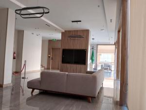 a living room with a couch and a flat screen tv at فندق حياة تاون ضبا in Ḑubā