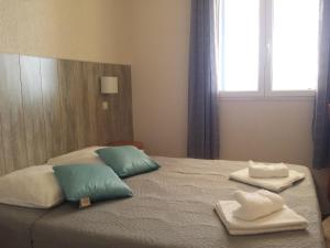 a bed with towels on it with a window at Bel Mare in Cargèse