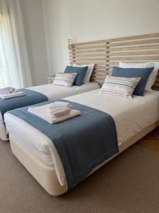 two beds in a room with blue and white at Cantinho da Carminho in Amoreira +27 photos