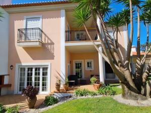 a large house with a balcony and palm trees at Cantinho da Carminho in Amoreira