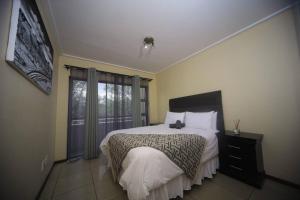 a bedroom with a large bed and a window at Golfers Estates in Roodepoort