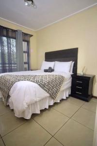 a bedroom with a bed and a dresser and a window at Golfers Estates in Roodepoort