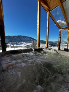 弗拉西克Vlasic Odmor - Villa Biser & spa的一座带雪的建筑中的热水浴缸