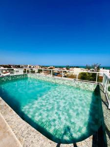 Flat Praia dos Carneiros Tamandaré في تامانداري: حمام سباحة مع المحيط في الخلفية