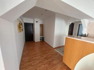 an attic room with white walls and a wooden floor at Cazare apartament Craiova in Craiova
