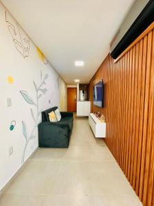 Flat Praia dos Carneiros Tamandaré في تامانداري: مدخل مع أريكة في غرفة مع جدار