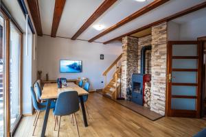 a room with a table and chairs and a fireplace at Kuća za odmor Vesna in Stari Laz