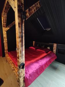 a bedroom with a bed with red and pink sheets at La Love room in Arbois