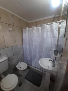 a bathroom with a white toilet and a sink at Gotas de Rocio in San Antonio Oeste