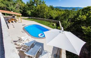 an umbrella and chairs and a swimming pool at Awesome Home In Krk With Wifi in Risika +28 photos