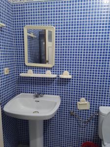 a blue tiled bathroom with a sink and a mirror at Dar hana in Asilah +32 photos