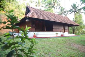 a small house in a field with a yard at Poovar Heritage Homes in Pūvār +2 photos
