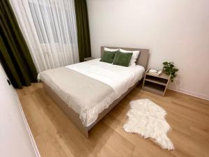アルバ・ユリアにあるSunset Apartmentsのベッドルーム1室(ベッド1台、白いラグ付)