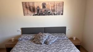 a bedroom with a bed with a picture on the wall at CA LIDIA-Apartamentos Turísticos EL CAMPANAR 1 in Benimantell