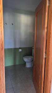 a bathroom with a toilet and a door open at CA LIDIA-Apartamentos Turísticos EL CAMPANAR 1 in Benimantell