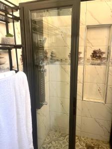 una doccia con una porta in vetro in un bagno di Résidence Atlantis F2 avec balcon vue sur mer a Dakar