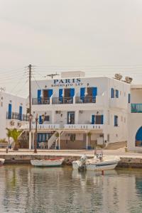 a large white building with boats in the water at Paris Rooms in Antiparos Town