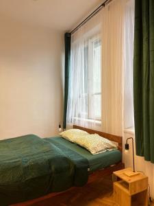 a bedroom with a bed in front of a window at W94 Hostel in Kraków