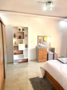 una camera da letto con un letto, un comò e uno specchio di Résidence Atlantis F2 avec balcon vue sur mer a Dakar