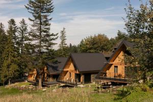 a large log cabin in the woods with trees at The Sopa - heritage premium houses in Zakopane