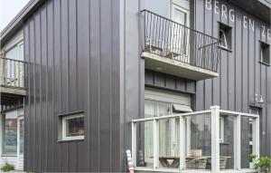 ein graues Gebäude mit einem Balkon und Fenstern in der Unterkunft Berg En Zee 3 in Bergen aan Zee