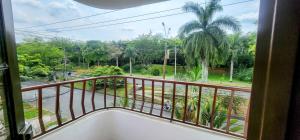 a balcony with a view of a palm tree at Acogedor Apto Al Lado Del Parque Del Ingenio in Cali