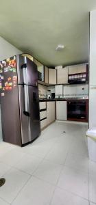 a kitchen with a stainless steel refrigerator in it at Acogedor Apto Al Lado Del Parque Del Ingenio in Cali